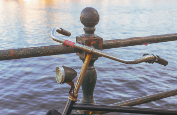 An old bicycle leaning against a metal railing